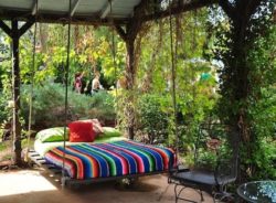 diy-porch-swing-bed-with-pallet-wood-material-and-striped-bedding-set-and-green-bed-coveralso-stand-candle-holder-and-outdoor-garden-space-and-iron-chair-furniture